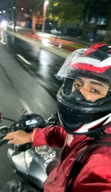 Entregador em rota durante chuva forte, à noite